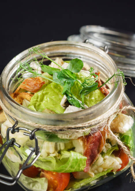 mediterraner Salat mit getrockneten Tomaten, Kräutern und Fata-Käse in einem Einmachglas