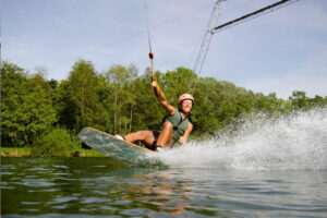 Süsel Seeparx - Wakeboarderin dicht über dem Wasser in den Knien