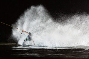 Süsel Seeparx Wakeboard Park - Wakeboarder im Dunklen angeleuchtet, spritzende Wasserfontäne