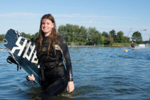 Süsel Seeparx - Wakeboarderin auf dem Weg aus dem Wasser raus mit dem Wakeboard unter dem Arm