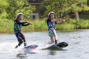 Süsel Seeparx Wakeboard Park - 2 Kids beim Wakeboarden zusammen auf dem Wasser