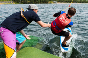 Süsel Seeparx - Crewmitglied gibt Wakeboarder Starthilfe